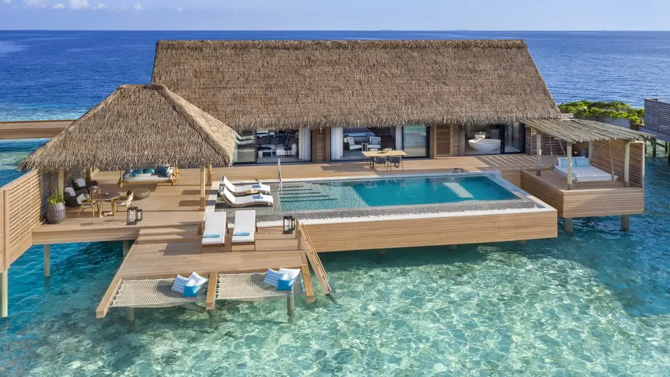 Villas en la playa entre vegetación, junto al mar