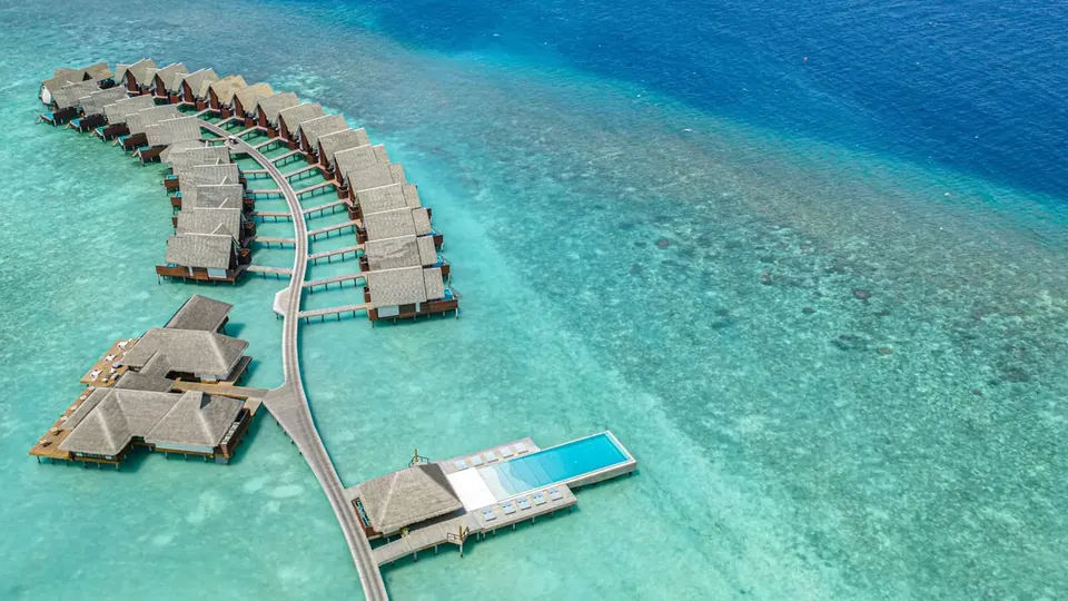 Overwater villas extending into a blue lagoon