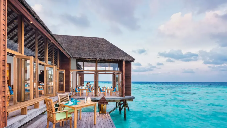 Deque de spa sobre a água, com cadeiras voltadas para o mar azul-turquesa