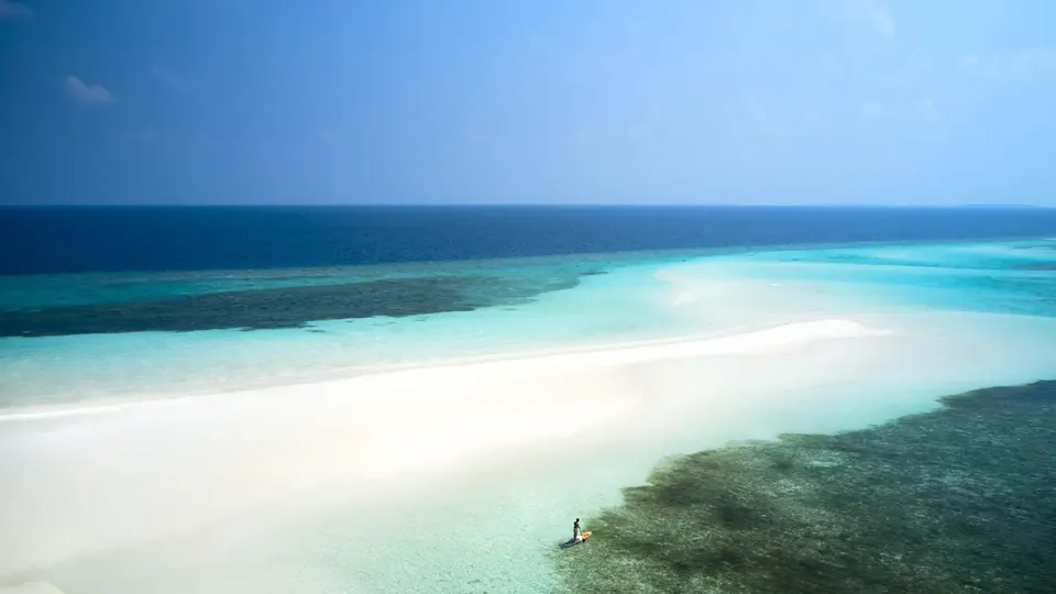 Um banco de areia branco em águas turquesa rasas
