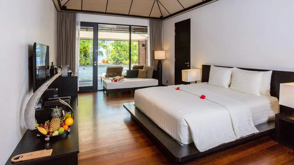 Starannie posłane łóżko w willi udekorowane kwiatami