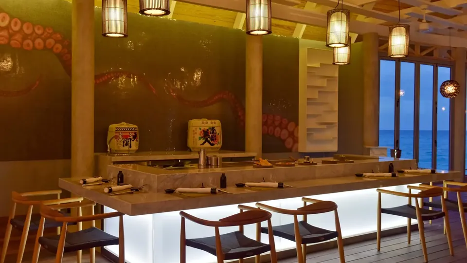 Bar de resort com luzes acolhedoras de lanternas e bancos ao longo do balcão