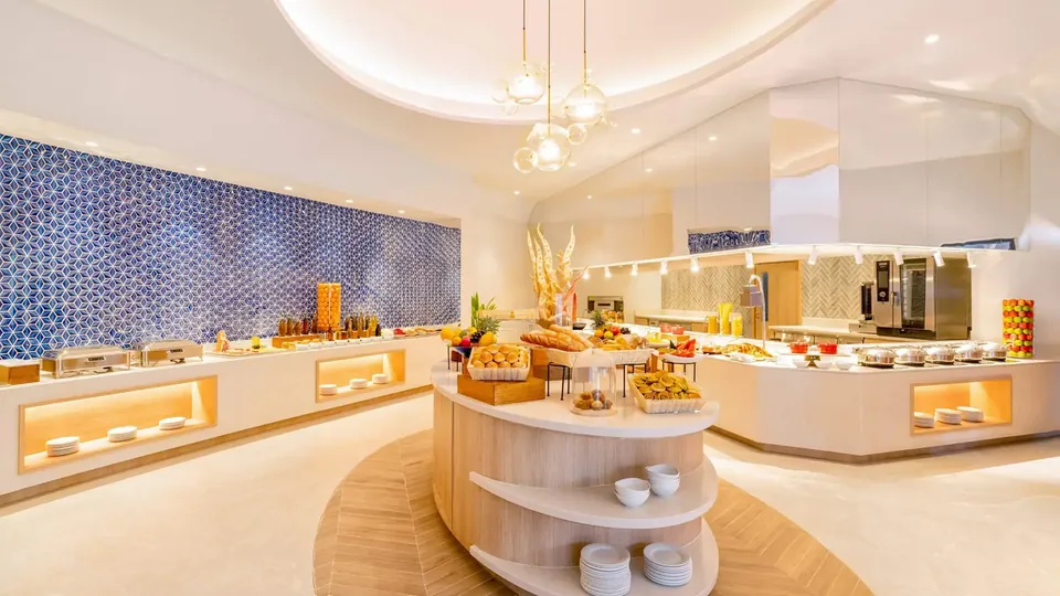 Restaurante de resort bem iluminado, com balcões de comida fresca