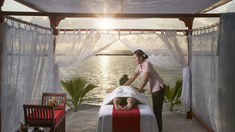 Denize bakan açık hava spa köşkünde masaj yapan bir terapist
