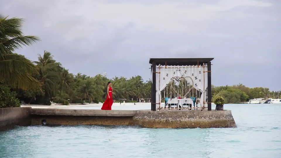 Um gazebo de casamento decorado com flores em um deck sobre a lagoa